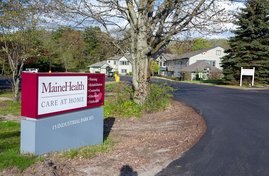 Close-up of road sign, driveway, and main entrance to MaineHealth Care at Home offices in Saco