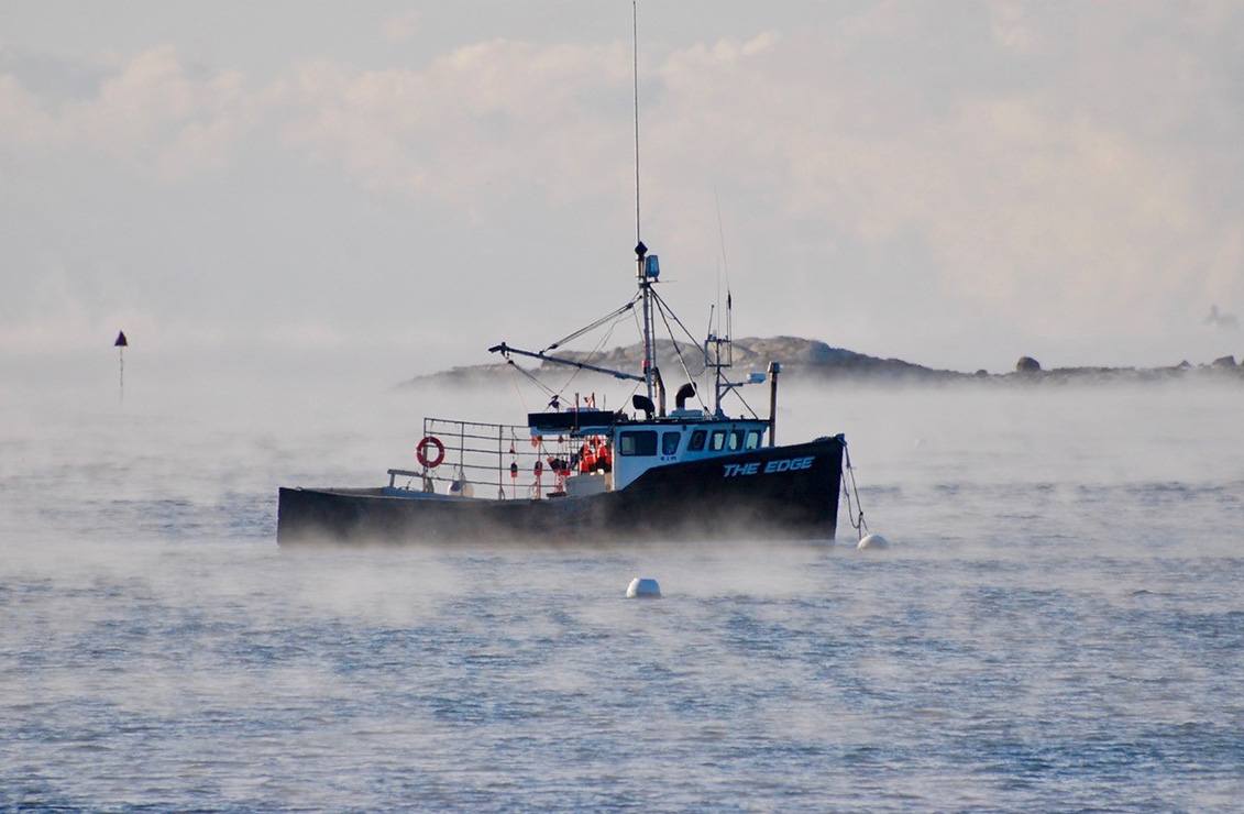 fishing boat at early morning on a cold day with fog on the water